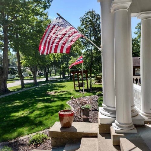 U.S. flag and Norwegian vimpel are displayed in front of Nordic Pineapple B&B.