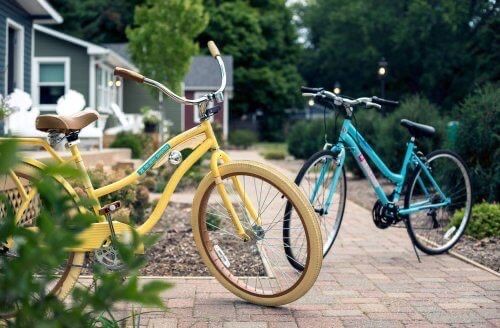 Two Hotel Saugatuck bikes are parked on the sidewalk outside the bungalows