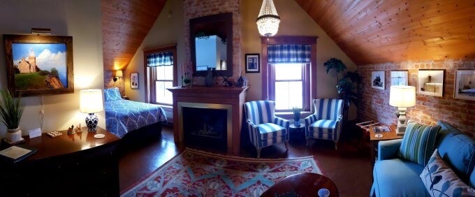 Keeper Dufrain room at Big Bay Lighthouse has a fireplace and seating area.