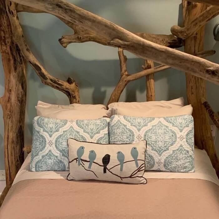 Tree branches form the headboard of a bed at Goldberry Woods, high on our list of Michigan B&Bs you need to try..