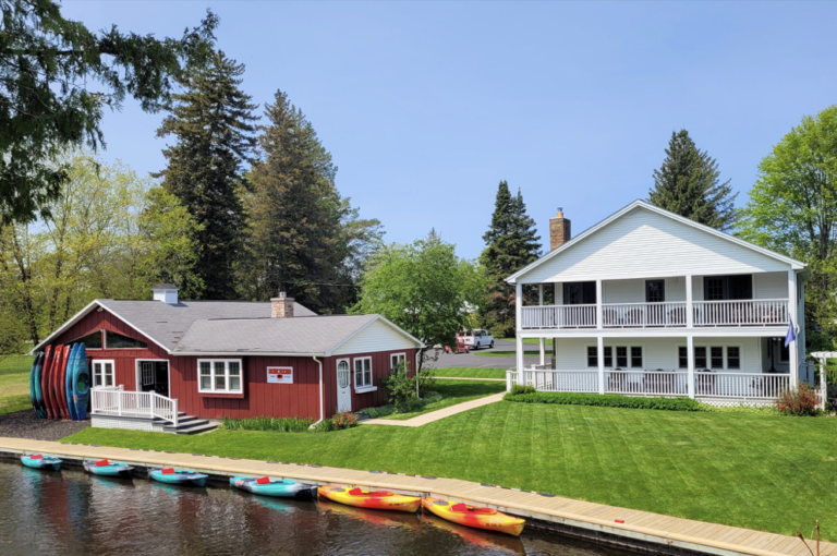 Borchers Ausable Canoe & Kayak with riverside B&B- two story white building that is a B&B with a red building next door for kayak rental- all along the AuSable River