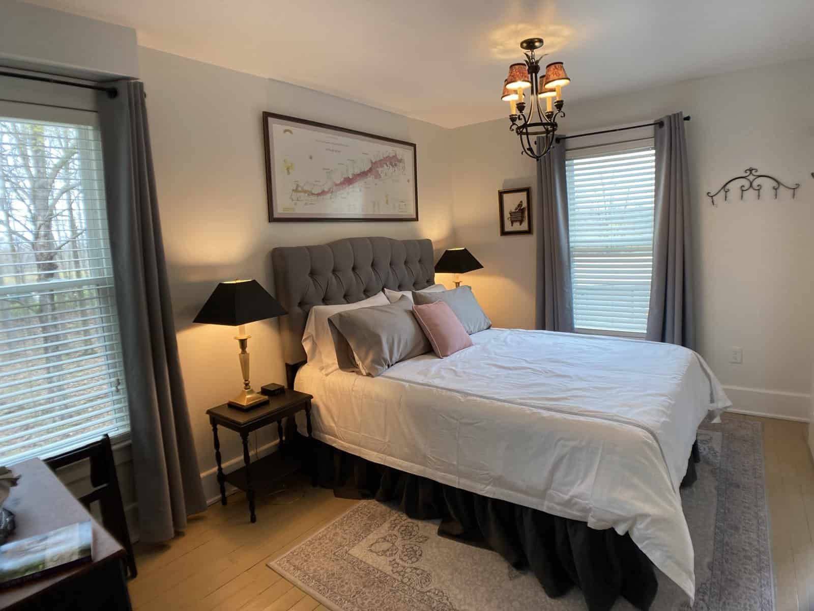 Grey Fabric Headboard with white duvet and map picture above