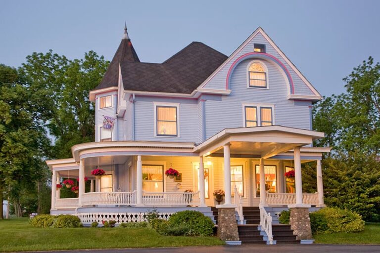 Blue Victorian with white trim lite at night