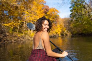 Woman kayaking at the Goldberry Woods wearing a plaid shirt toes around her middle