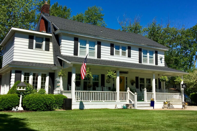 White two story colonial with black shutters and a flag at the Dutch Colonial Inn in Holland