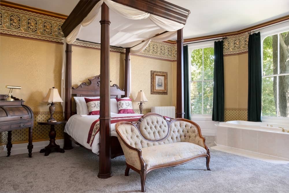 Emerald Guest Room at Jade Estate is a grand canopy with decorative settee in front