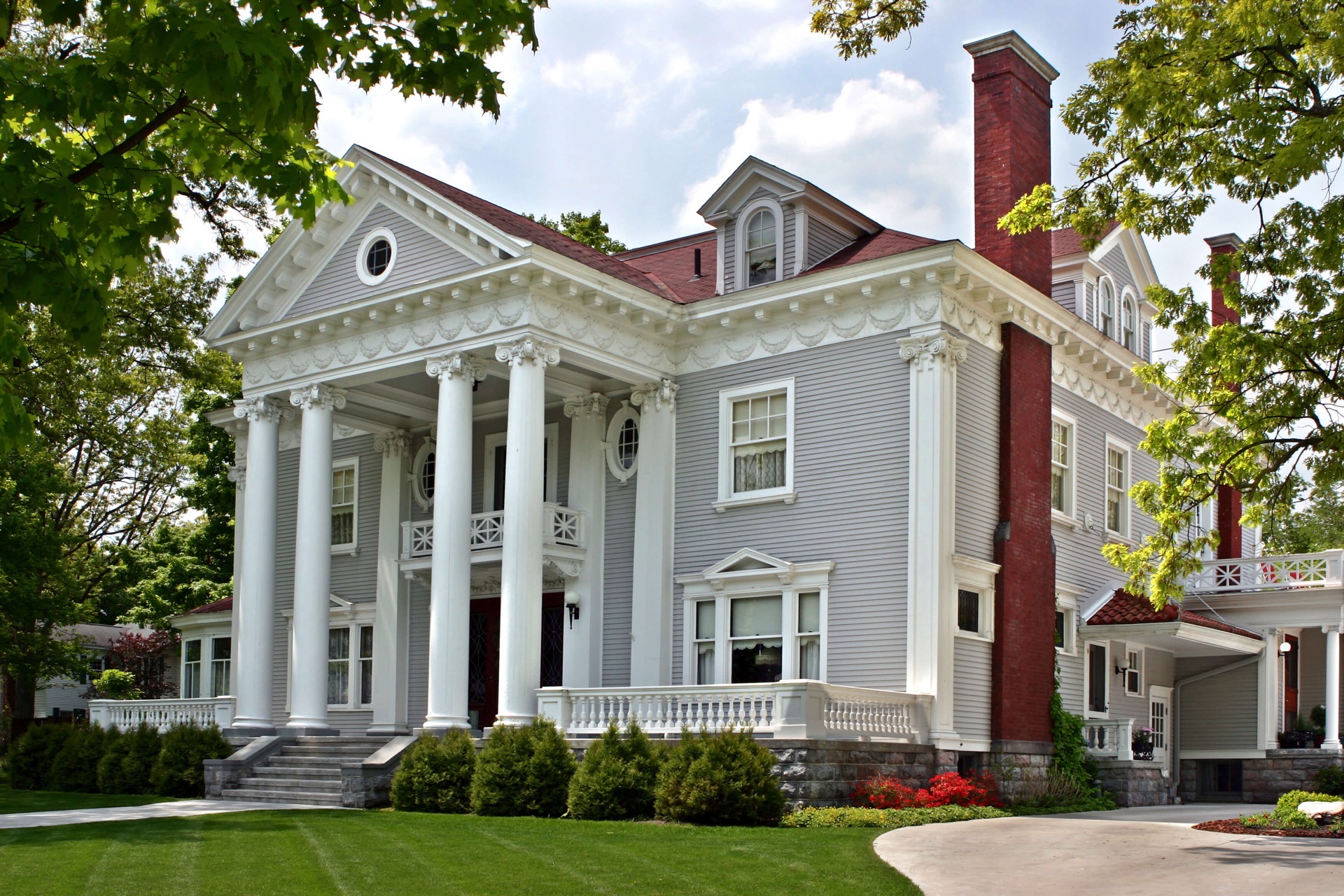 Three story Neo Classic Grey with white trim mansion which is now the Wellington Inn Traverse City