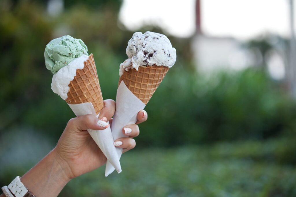 a woman's arm holding two ice cream cones