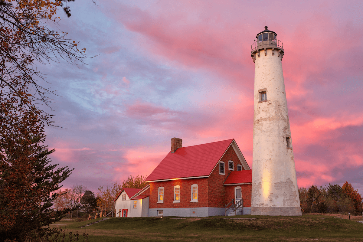 Tawas Point Lighthouse at sunset with pink hues skies