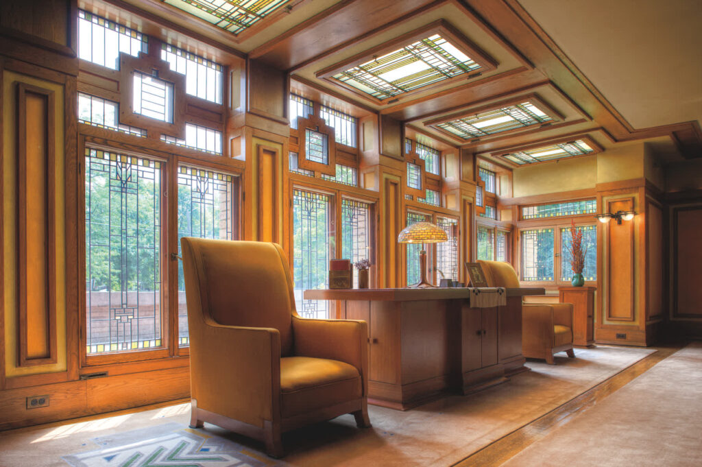 Meyer May House Living room with leather chairs and leaded stained glass windows