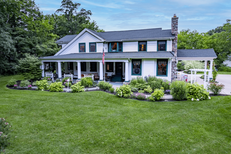 White farmhouse with stone chimney at the Maple Cove B&B