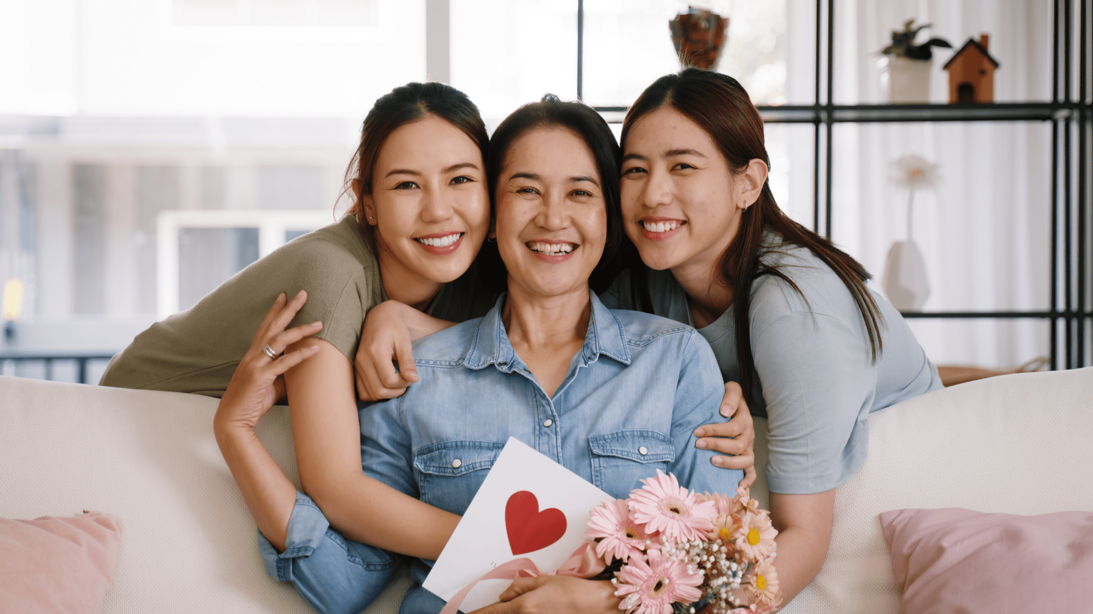 Mother with two daughters with flowers in her hand