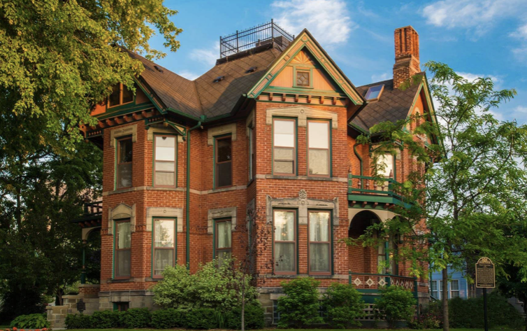 Historic Webster House. Three story red brick mansion with blue skies in the background