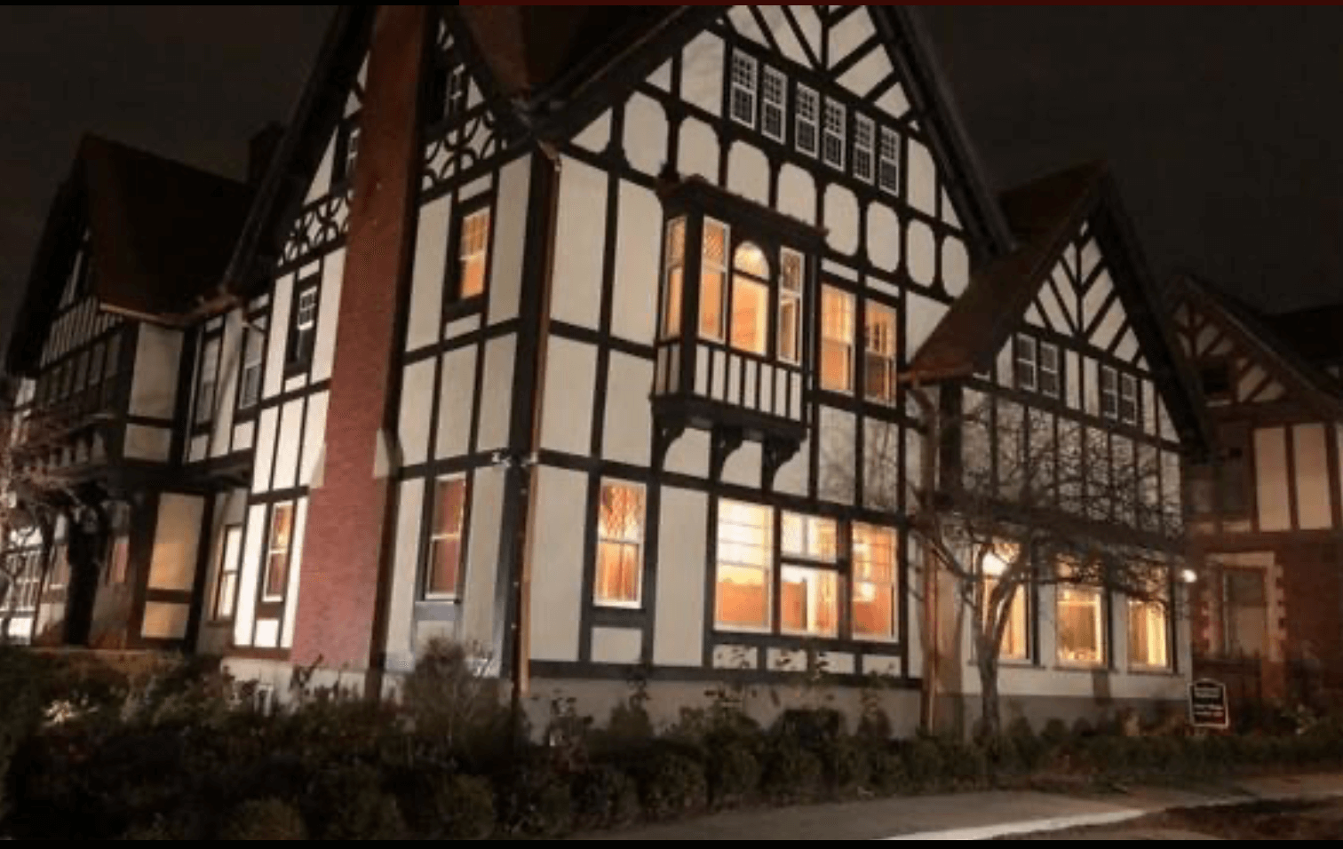 Three story mansion with brick chimney paintef in cream with brown trim. Frederick K. Stearns at night