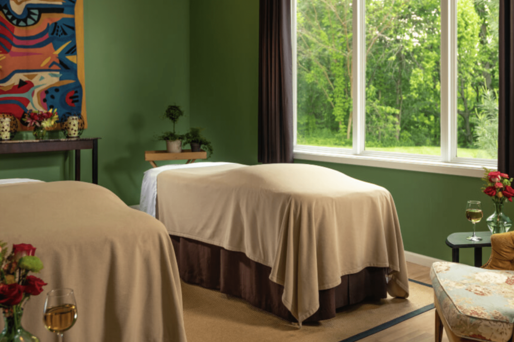 Two spa tables with white spreads and green walls at the Castle in the Country