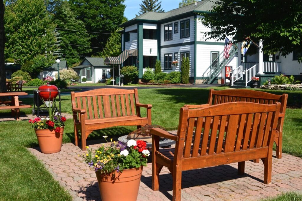 Seating at the Victoria Resort in South Haven with potted flowers and a barbecue