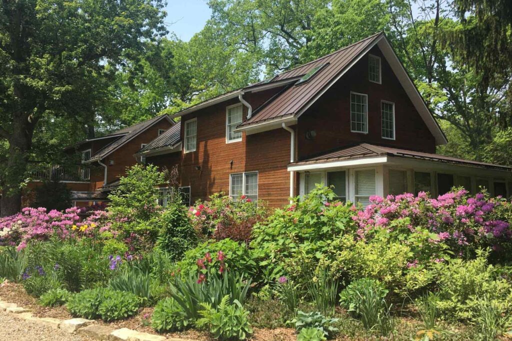 Brown sided building at Goldberry Woods surrounded by flowers