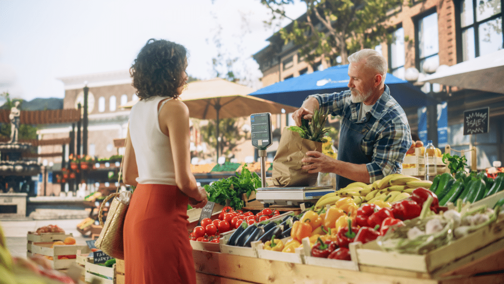 Young woman at a farmers market buying vegetables