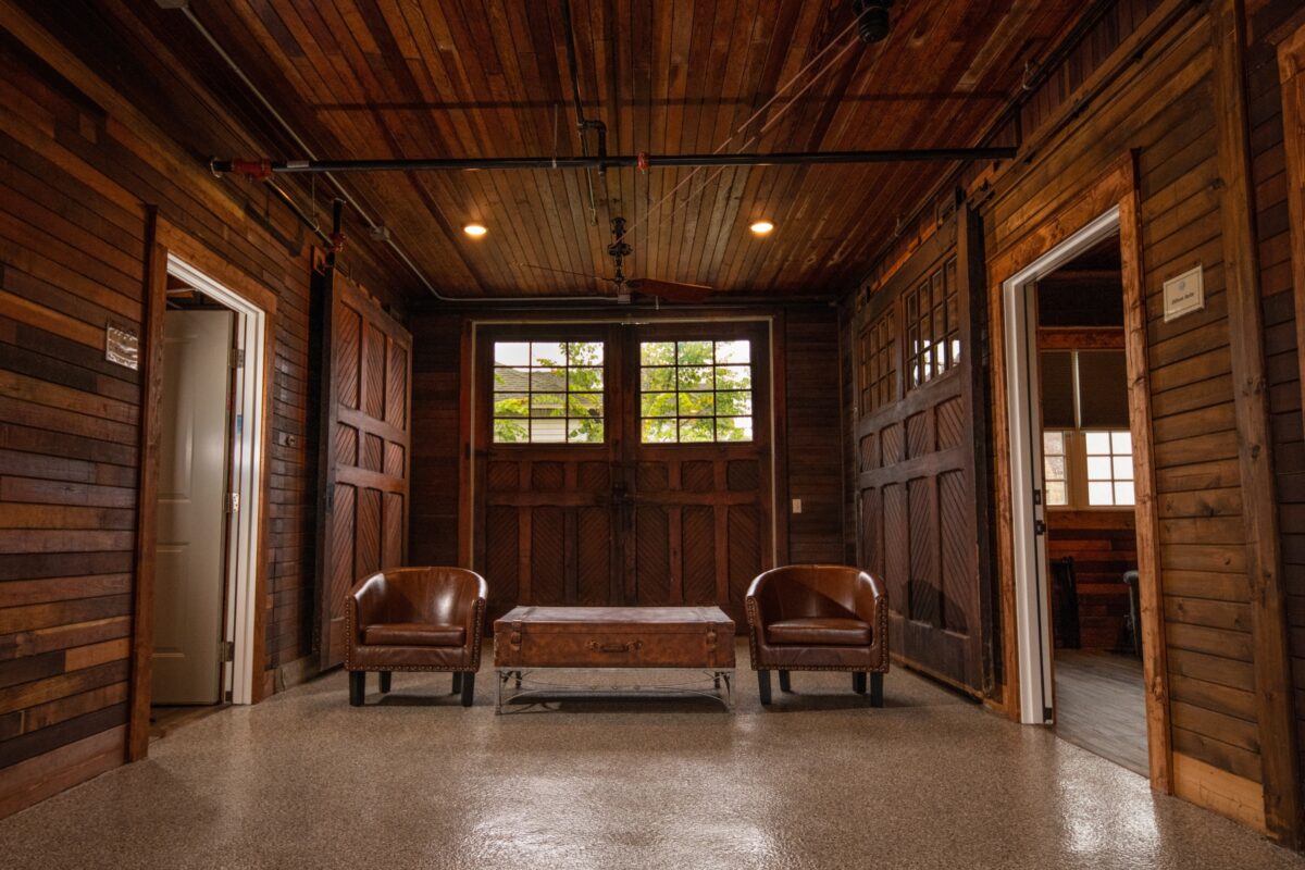 Two leather club chairs with wooded wall at the Cartier Mansion