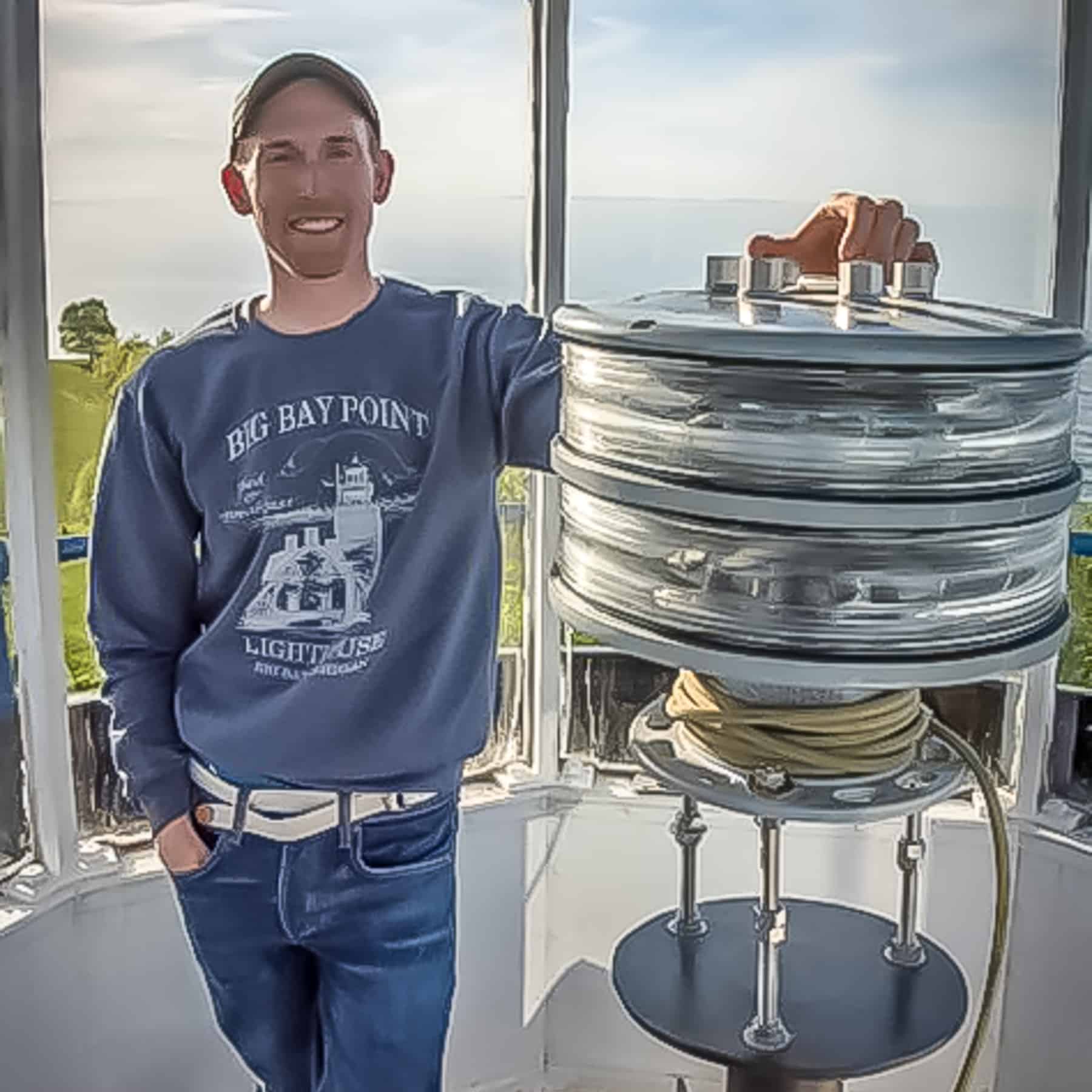 Nick leaning against the lighthouse lens at the Big Bay Lighthouse