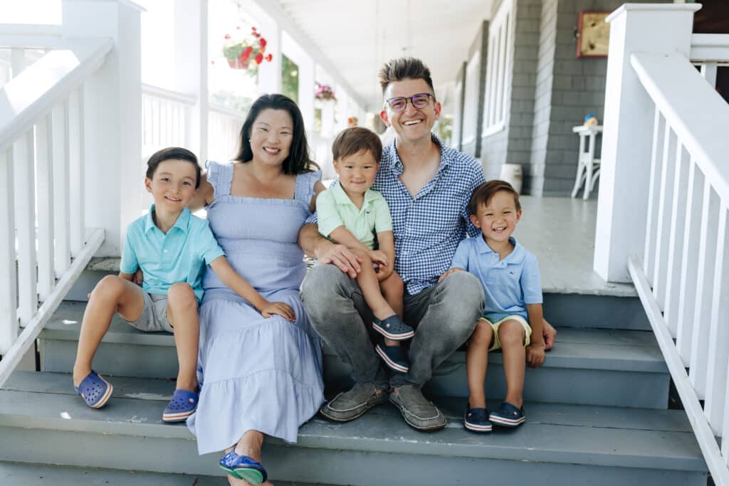 Innkeeper Ryan Berndt with family on steps of Canfield House Bed and Breakfast in Onekama