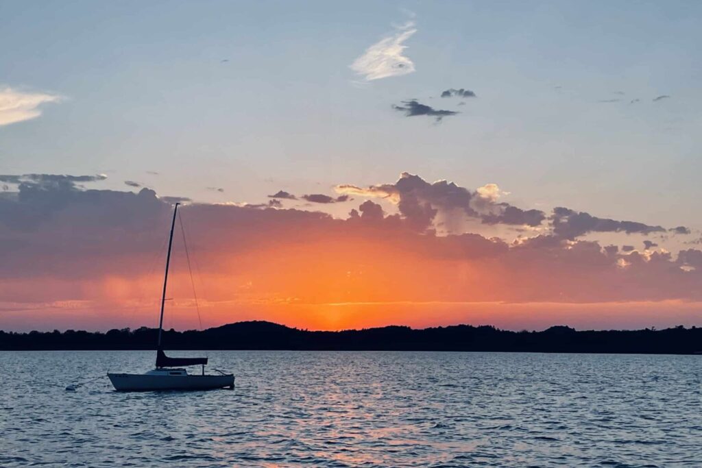 A sailboat moored at sunset on Portage Lake