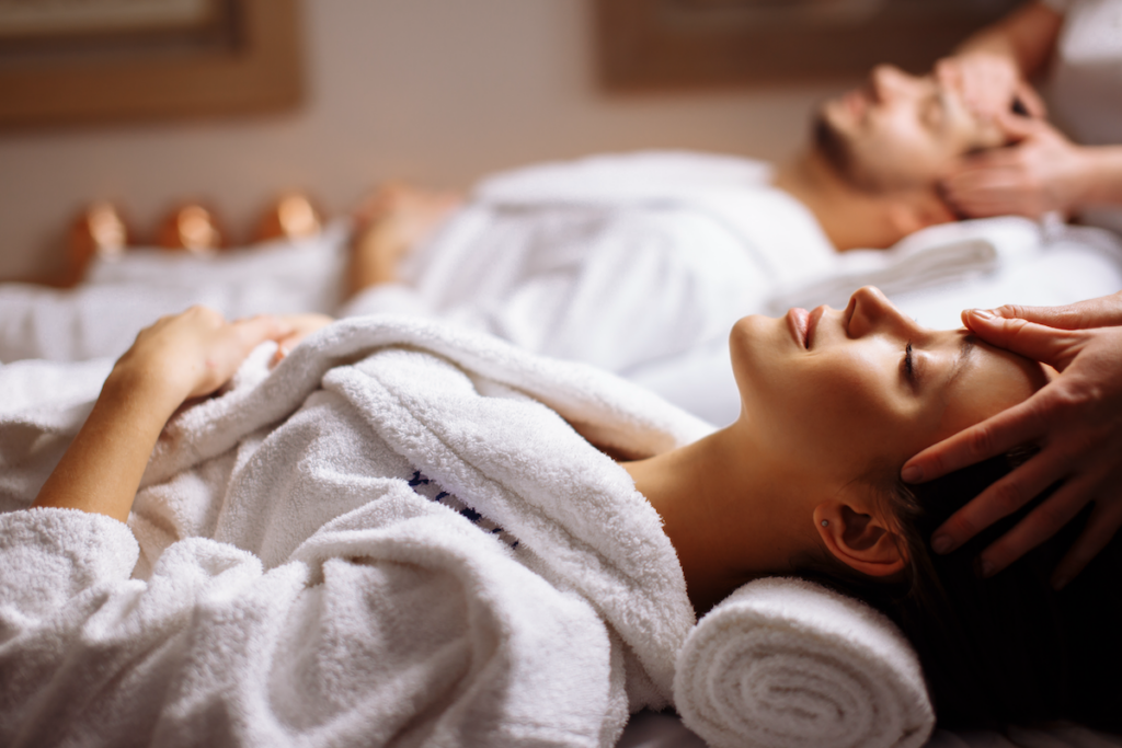 Couple om white robes getting a massage