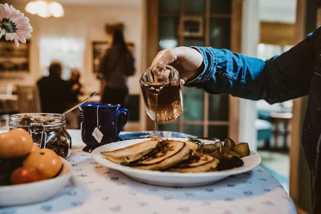 Woman pouring syrup over her pancakes at the Garden Grove Inn